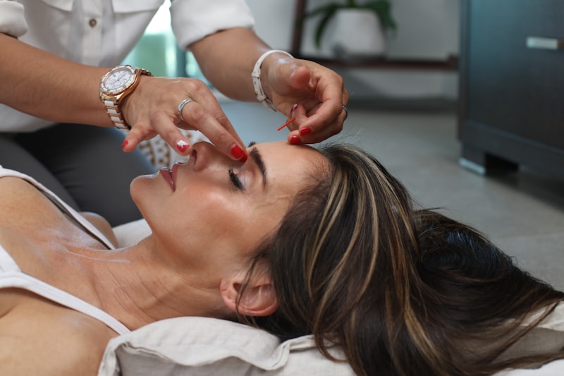 Aplicación de un tratamiento facial con aparatología sobre el rostro de una clienta